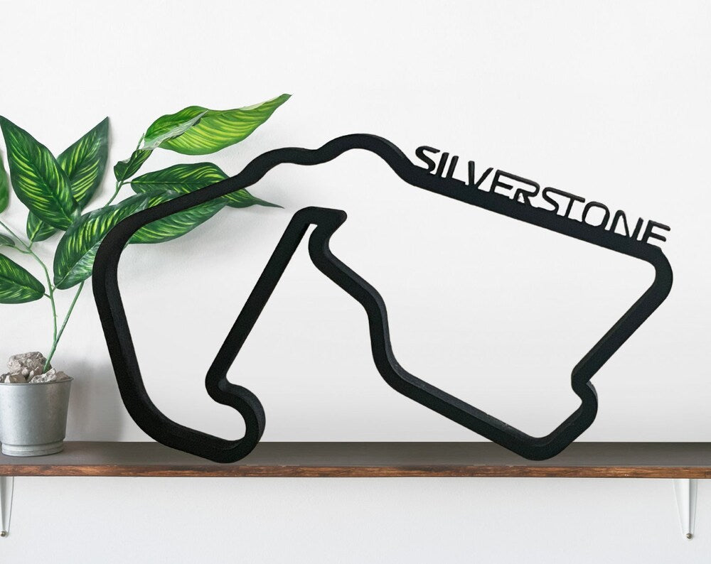 a track outline for the silverstone racing track commonly used in the f1 series, made from mdf, painted black and has the silverstone name along the top right of the track straight